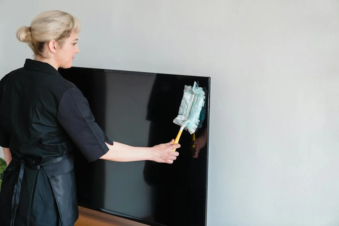 Lady cleaning a tv for a move out cleaning in Union, NJ.